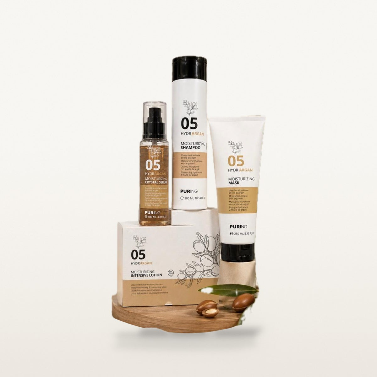 Coffret hydratation 05 : sérum 100 ml, shampooing 300 ml, tube de masque 250 ml et boîte de lotion, sur un plateau en bois